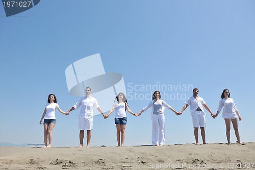 Image of happy people group have fun and running on beach