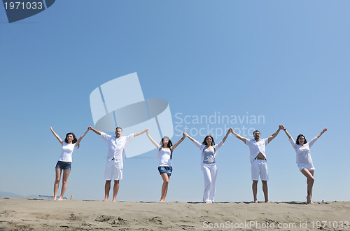 Image of happy people group have fun and running on beach