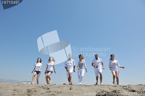 Image of happy people group have fun and running on beach