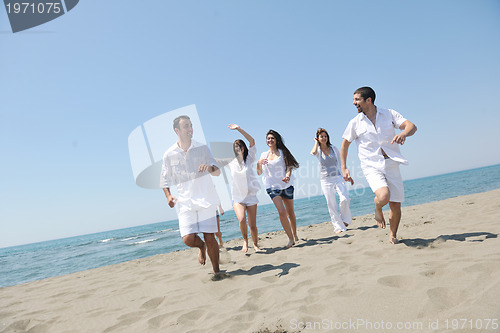 Image of happy people group have fun and running on beach