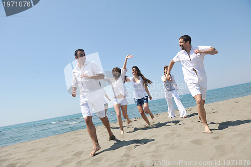 Image of happy people group have fun and running on beach