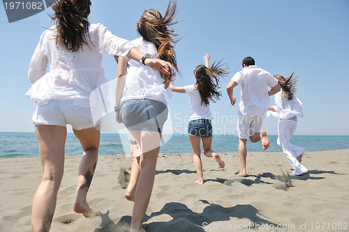 Image of happy people group have fun and running on beach
