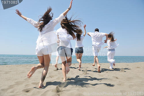 Image of happy people group have fun and running on beach