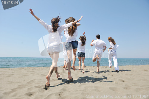 Image of happy people group have fun and running on beach