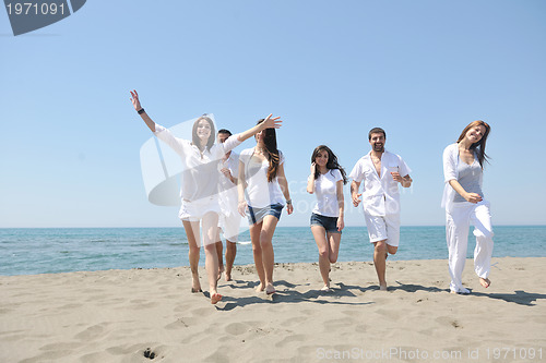 Image of happy people group have fun and running on beach