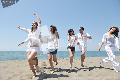 Image of happy people group have fun and running on beach