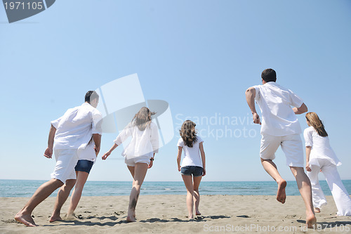 Image of happy people group have fun and running on beach