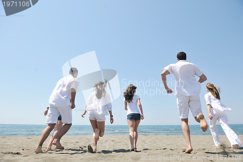 Image of happy people group have fun and running on beach
