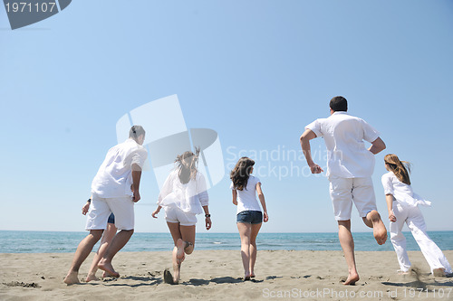 Image of happy people group have fun and running on beach