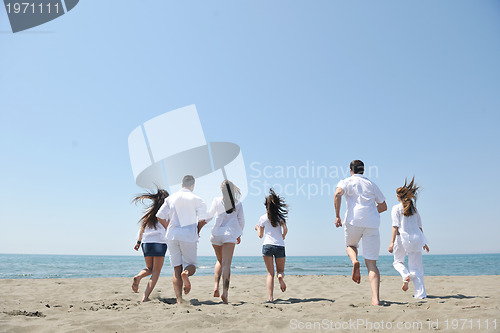 Image of happy people group have fun and running on beach