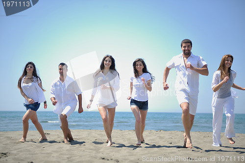 Image of happy people group have fun and running on beach