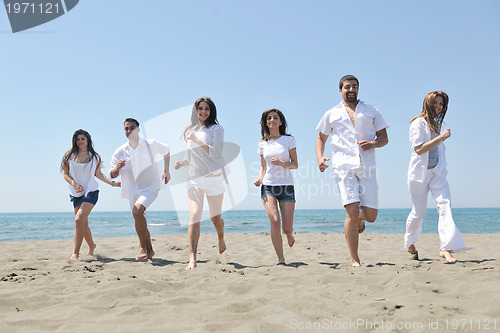 Image of happy people group have fun and running on beach