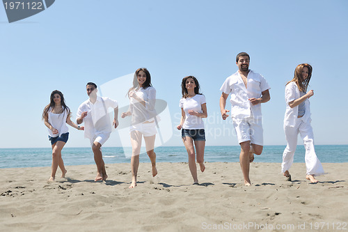 Image of happy people group have fun and running on beach