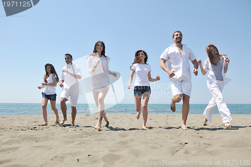 Image of happy people group have fun and running on beach