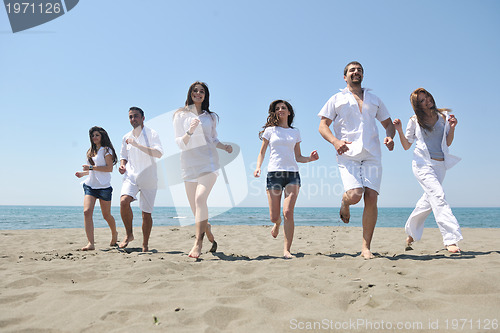 Image of happy people group have fun and running on beach