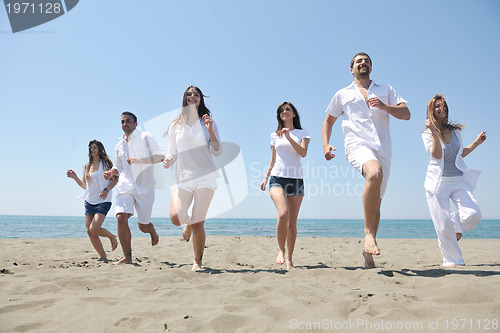 Image of happy people group have fun and running on beach