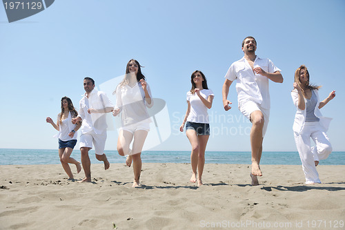 Image of happy people group have fun and running on beach
