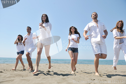 Image of happy people group have fun and running on beach