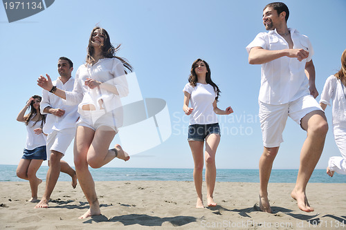 Image of happy people group have fun and running on beach