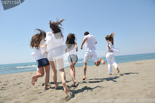 Image of happy people group have fun and running on beach