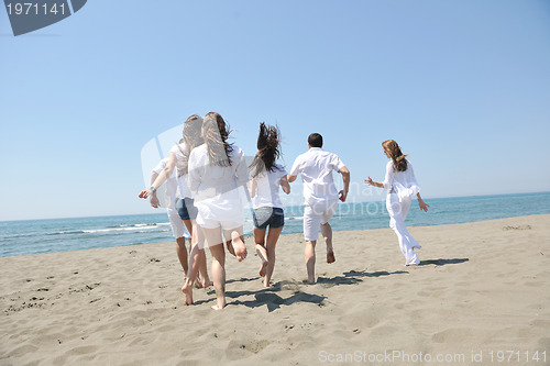 Image of happy people group have fun and running on beach