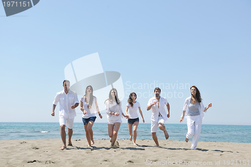 Image of happy people group have fun and running on beach