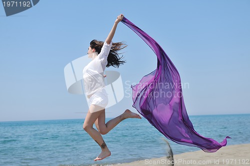 Image of beautiful young woman on beach with scarf