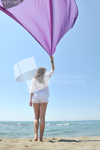 Image of beautiful young woman on beach with scarf