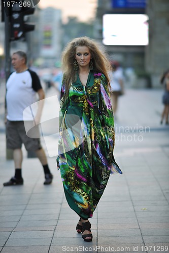 Image of elegant woman on city street at night