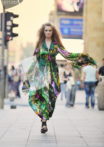 Image of elegant woman on city street at night