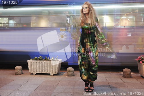 Image of elegant woman on city street at night