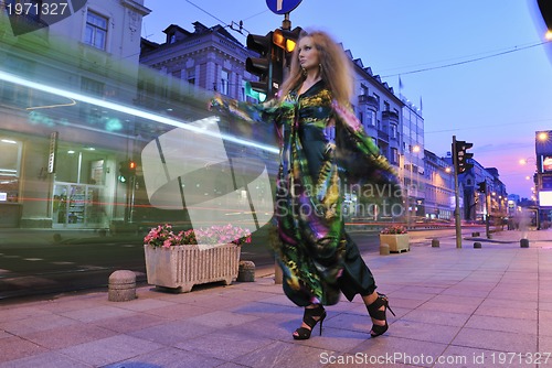 Image of elegant woman on city street at night