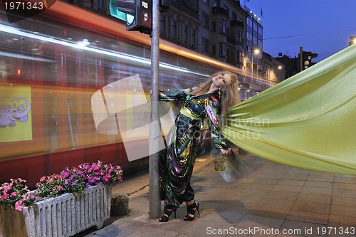 Image of elegant woman on city street at night