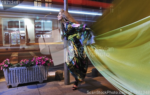 Image of elegant woman on city street at night