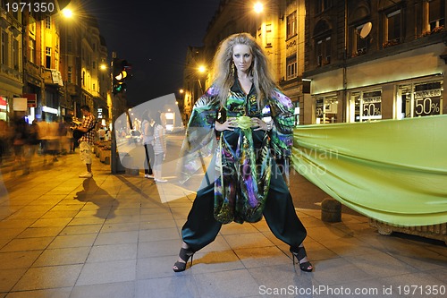 Image of elegant woman on city street at night