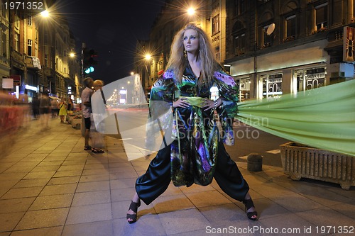 Image of elegant woman on city street at night