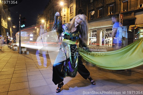 Image of elegant woman on city street at night