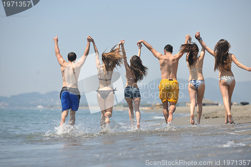 Image of happy people group have fun and running on beach