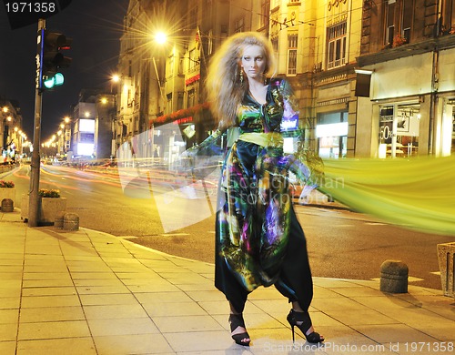 Image of elegant woman on city street at night