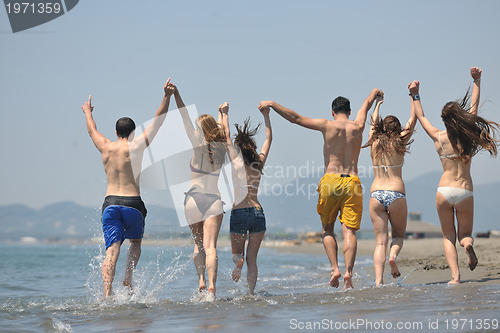 Image of happy people group have fun and running on beach