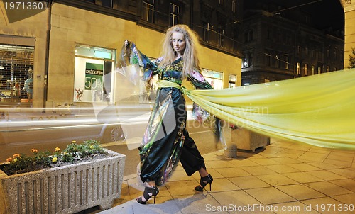 Image of elegant woman on city street at night