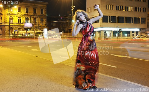 Image of elegant woman on city street at night