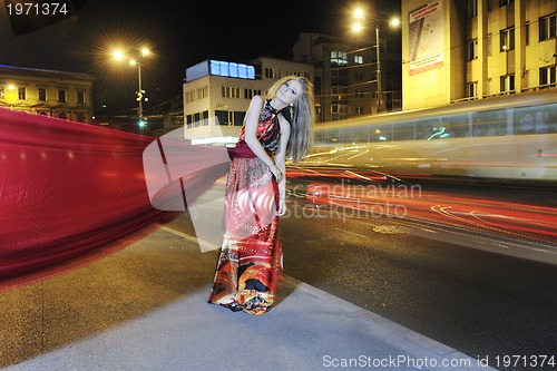 Image of elegant woman on city street at night