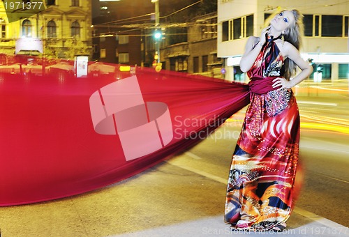 Image of elegant woman on city street at night