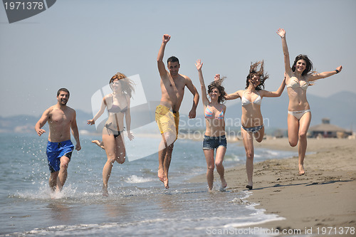 Image of happy people group have fun and running on beach