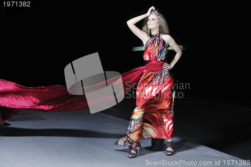 Image of elegant woman on city street at night