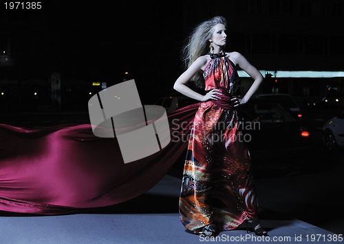 Image of elegant woman on city street at night