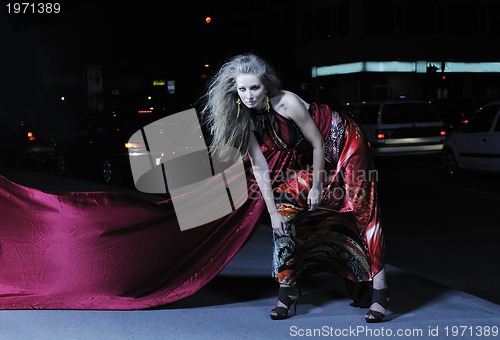 Image of elegant woman on city street at night