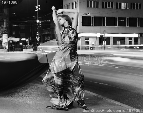 Image of elegant woman on city street at night