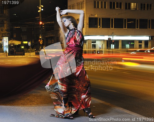 Image of elegant woman on city street at night